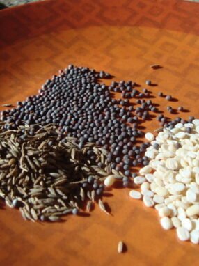 A wooden table with different types of beans on it.