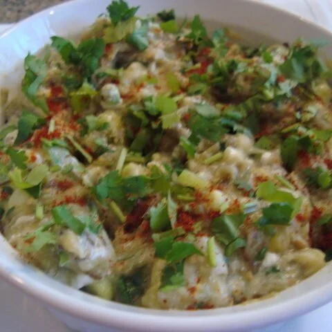 A bowl of food with some green stuff on it