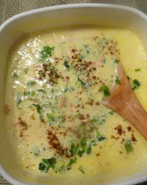 A bowl of soup with wooden spoon in it. Kadhi Yogurt Soup