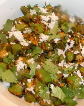 A bowl of food with green vegetables and rice.