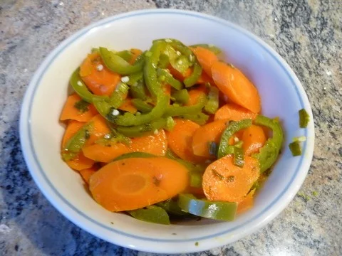 A bowl of sliced carrots and green peppers.