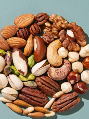 A variety of nuts arranged in a circular pattern on a blue background.